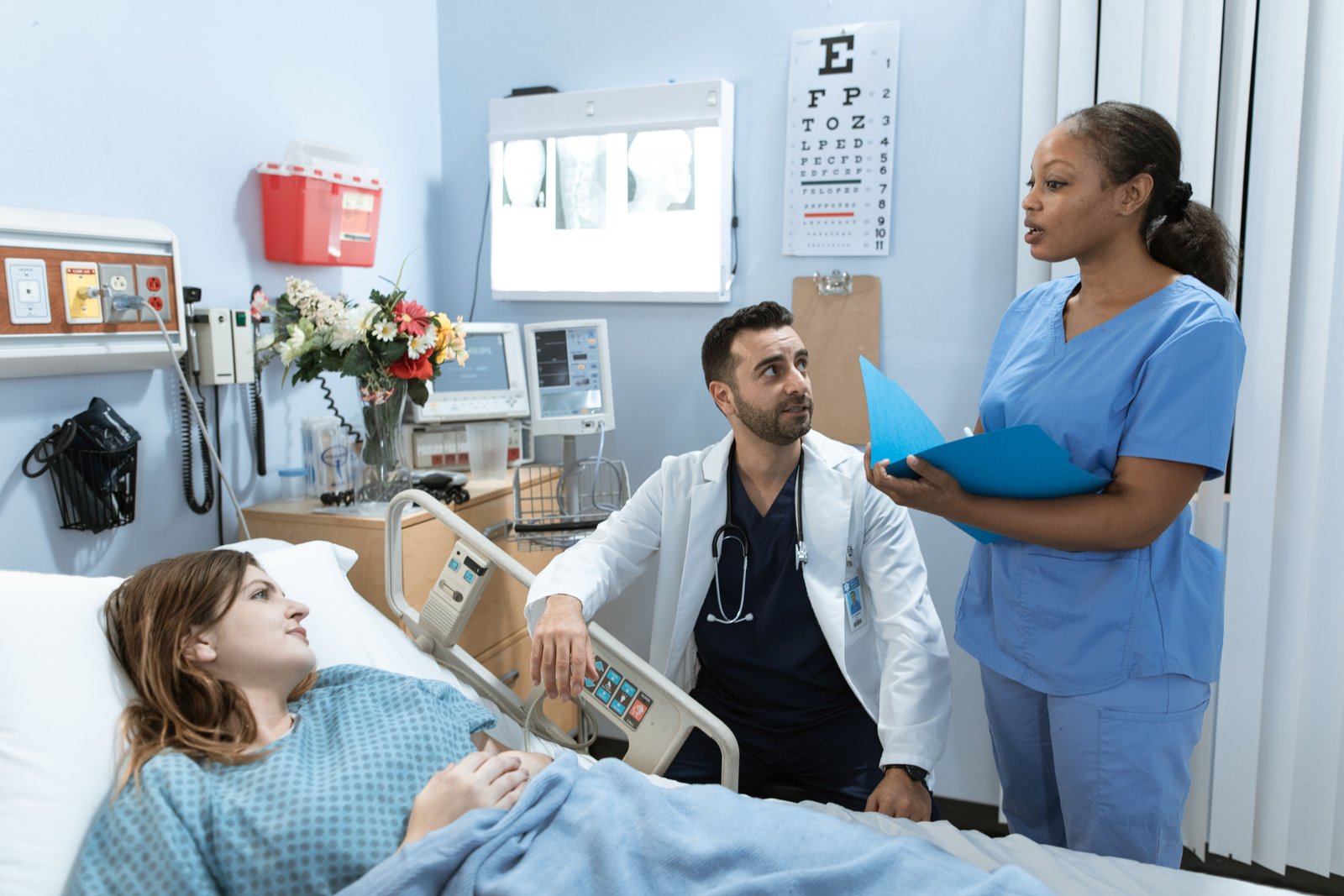 A nurse consulting with a colleague in a hospital hallway